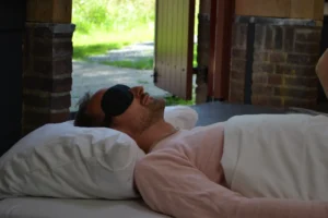 Participant lying comfortably with an eye mask during a ceremony at a psilocybin truffle retreat Netherlands.